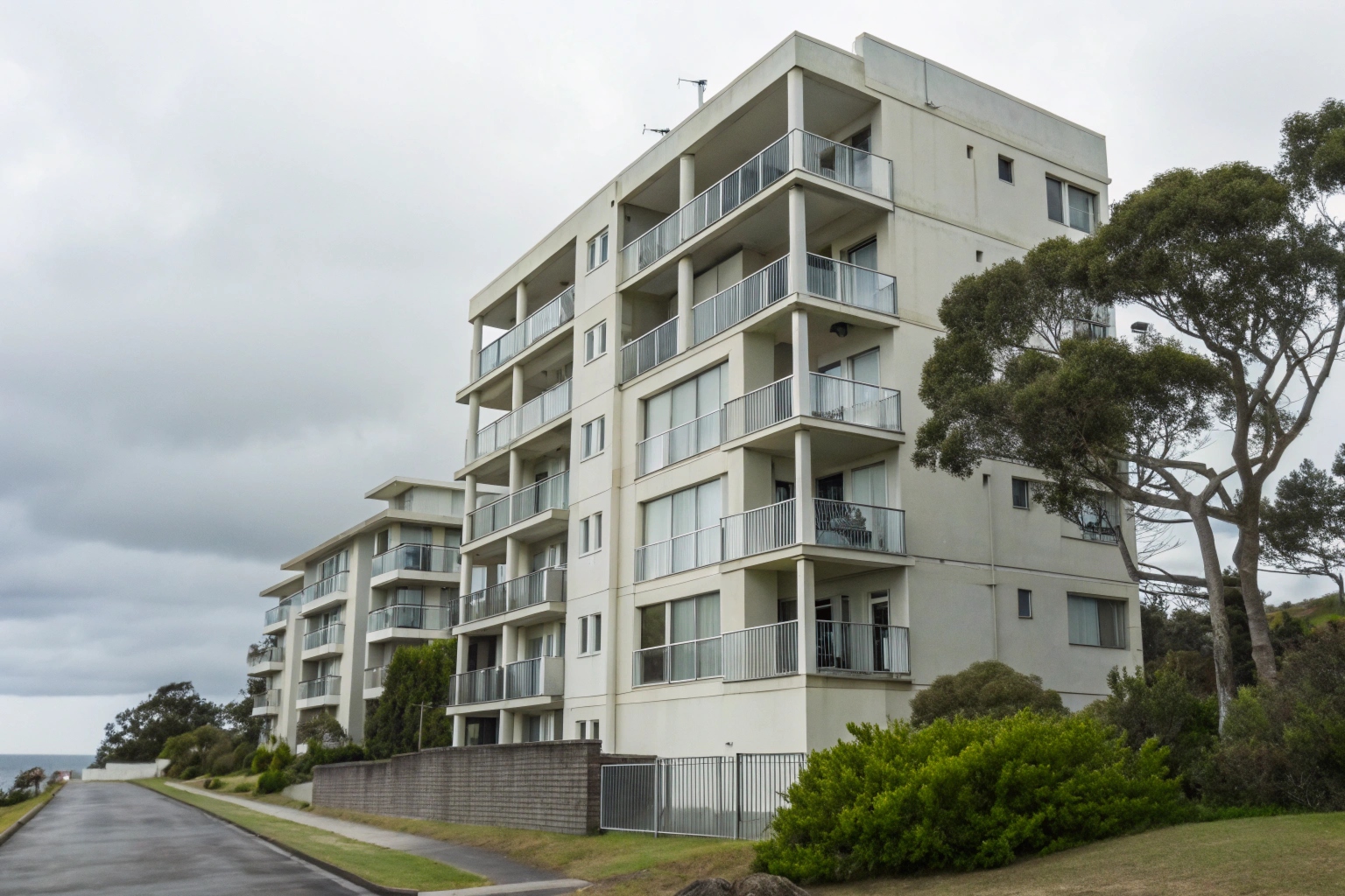 a-photorealistic-exterior-shot-of-a-mid-rise-resid Strata apartment building on the Central Coast NSW showing exterior weathering and moisture exposure