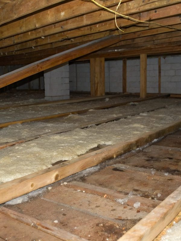 a-residential-subfloor-space-showing-sagging-and-d Moisture-damaged insulation batts in a residential subfloor space prior to replacement